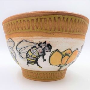 Stoneware pot decorated with bees and california poppies
