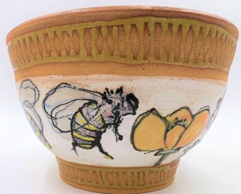 Stoneware pot decorated with bees and california poppies