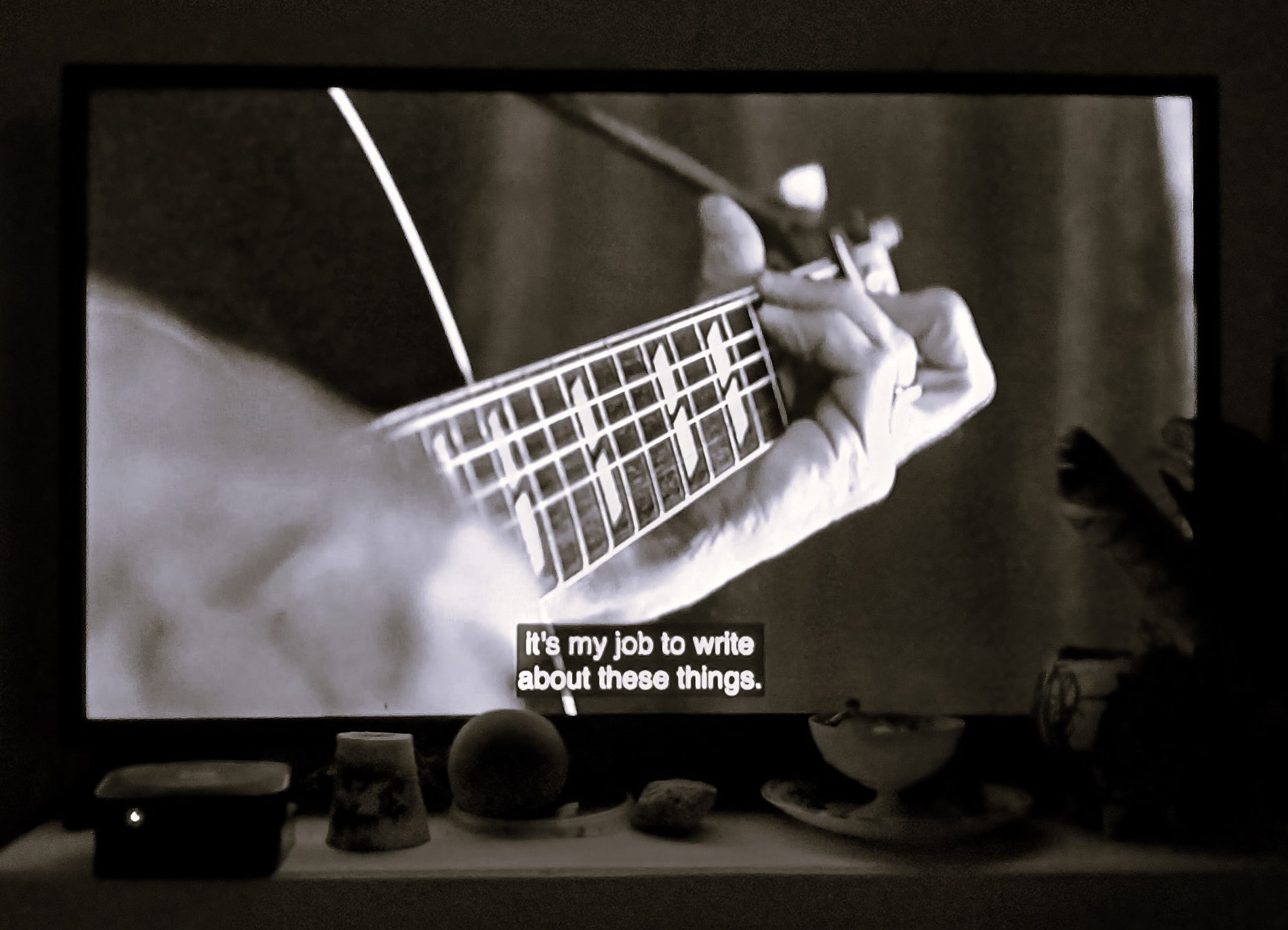 on a TV screen, hands playing guitar