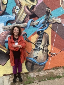 woman next to a painted mural on the outside of a building